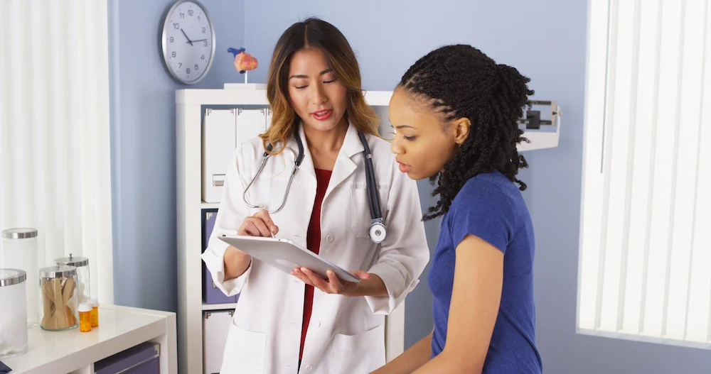 A doctor speaks with a patient during an appointment