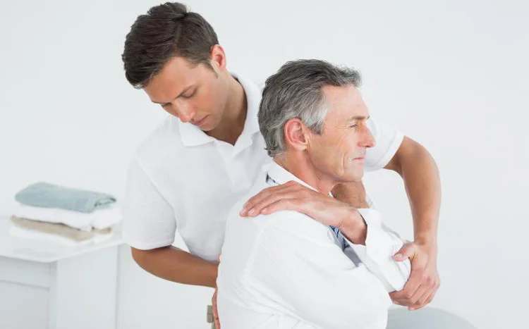 A chiropractor examines a patient's back